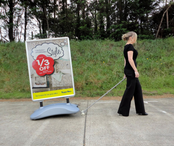 An image of a lasy towing a sightmaster 2 forecourt sign using the option trolley