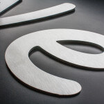 A picture of flat cut lettering cut from brushed aluminium dibond and applied to a black backing board